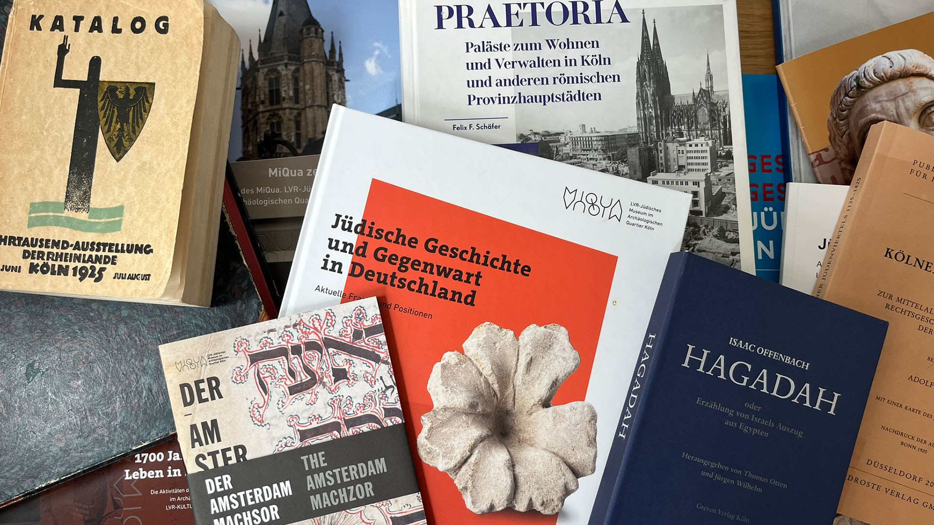 Eine Sammlung von Broschüren und Büchern mit Bezug zu den wissenschaftlichen Themen von MiQua.