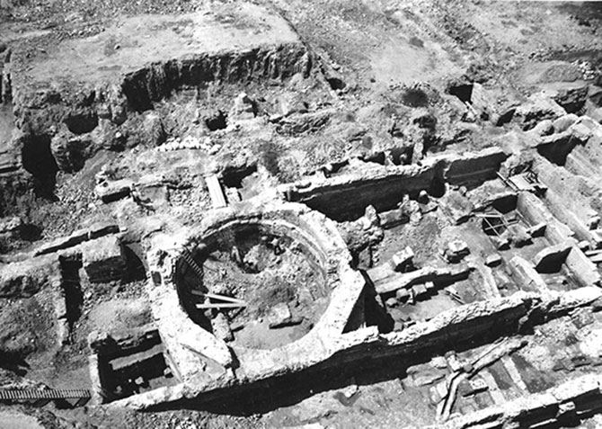 Schwarz-Weiß-Fotografie aus der Vogelperspektive: Eine historische Aufnahme der Ausgrabungen im Praetorium, dem römischen Statthalterpalast in Köln. Erkennbar ist eine offene Grabung mit Mauerwerken und einem Oktogon.