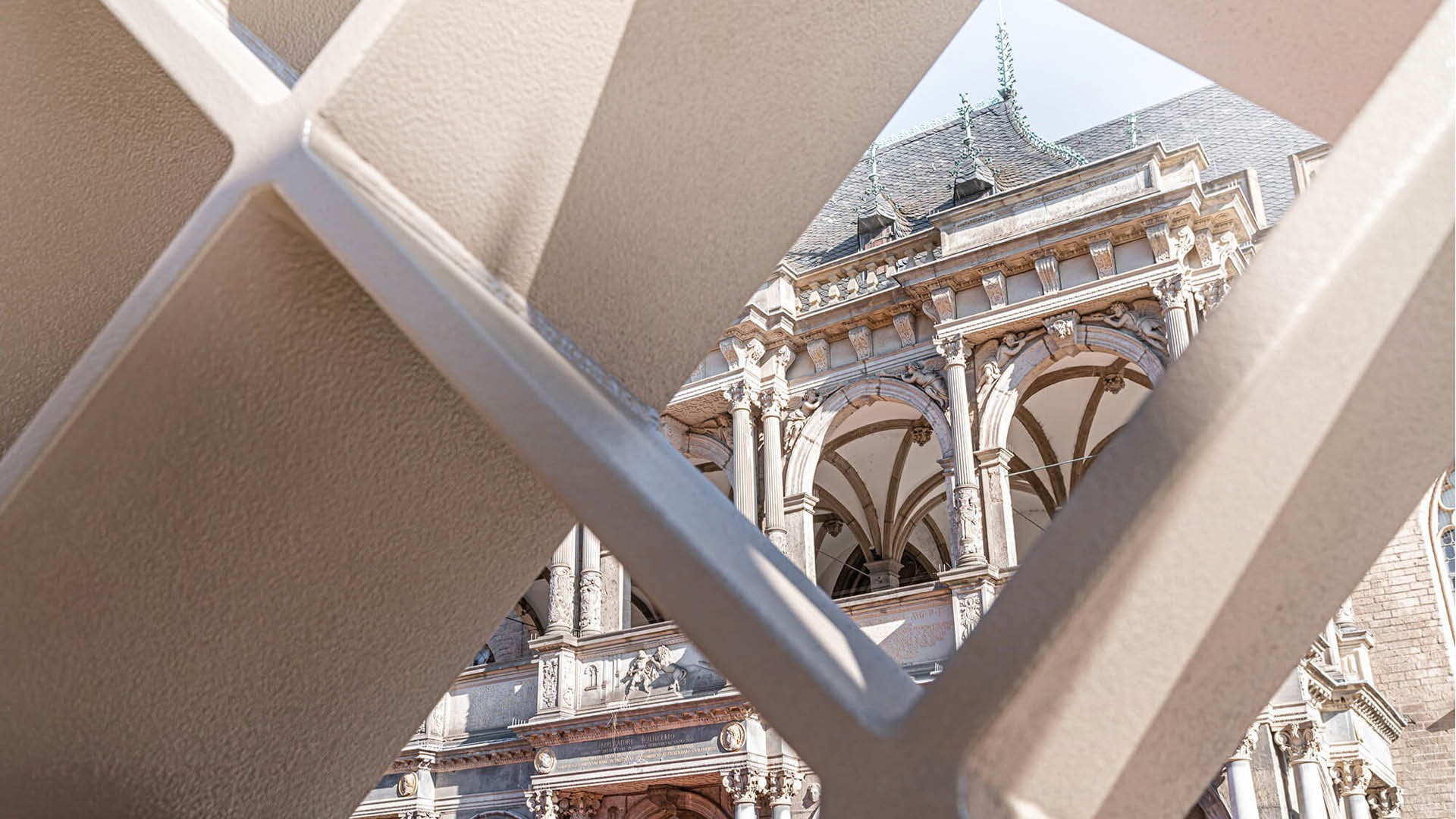 Ein Blick durch die Rauten-Stahlkonstruktion von MiQua auf das Historische Rathaus.