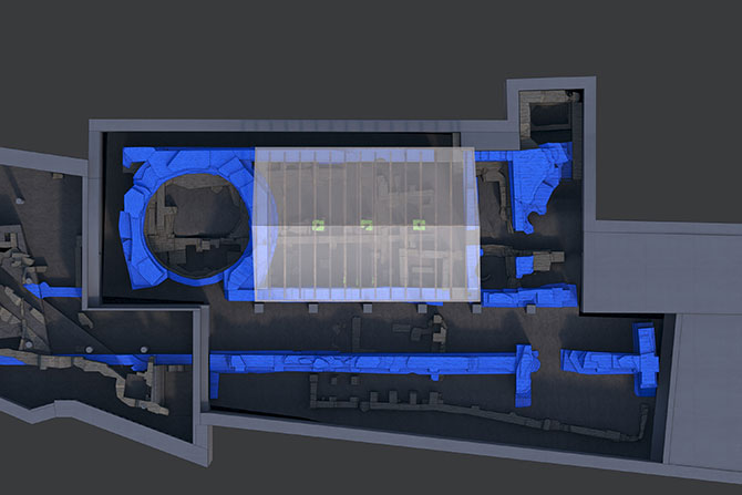 Ein digital erstellter, schematischer Grundriss archäologischer Strukturen mit hervorgehobenen Bereichen in Blau. Die Darstellung zeigt eine komplexe räumliche Anordnung mit mehreren Räumen, Gängen und Mauern, die teils erhalten, teils rekonstruiert sind. In der linken Hälfte ist eine runde Struktur erkennbar, möglicherweise eine Apsis oder ein Rundbau. Ein rechteckiger, transluzenter Bereich in der Mitte könnte eine moderne Überlagerung oder eine Interpretation der ursprünglichen Bebauung darstellen. Die Karte vermittelt einen Einblick in die spätantike Bauphase und dient vermutlich der archäologischen Analyse oder musealen Präsentation.