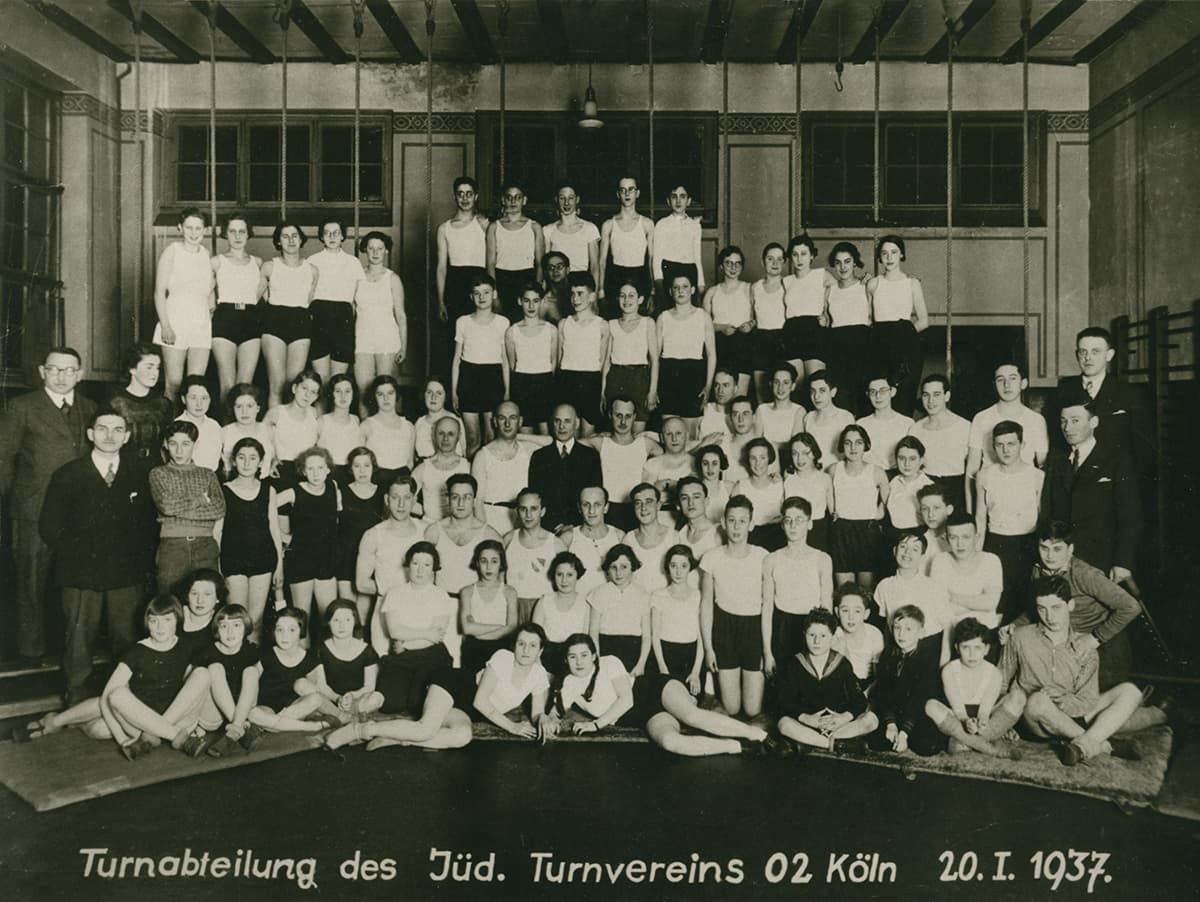 Gruppenfoto des Turnvereins, schwarz weiß, ca 70 Personen in der Sporthalle