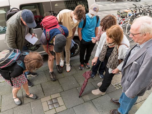 Familie Moses betrachtet Stolpersteine