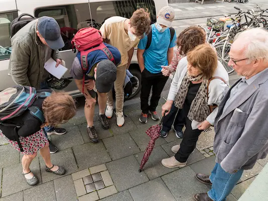 Familie Moses betrachtet Stolpersteine